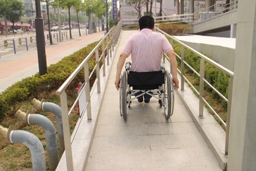 수동휠체어를 탄 중증장애인 모습.ⓒ에이블뉴스DB