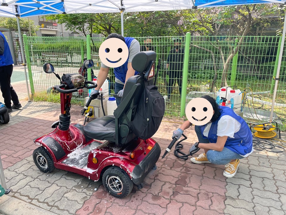 전동스쿠터에 거품을 내고 스팀 세척을 하는 모습