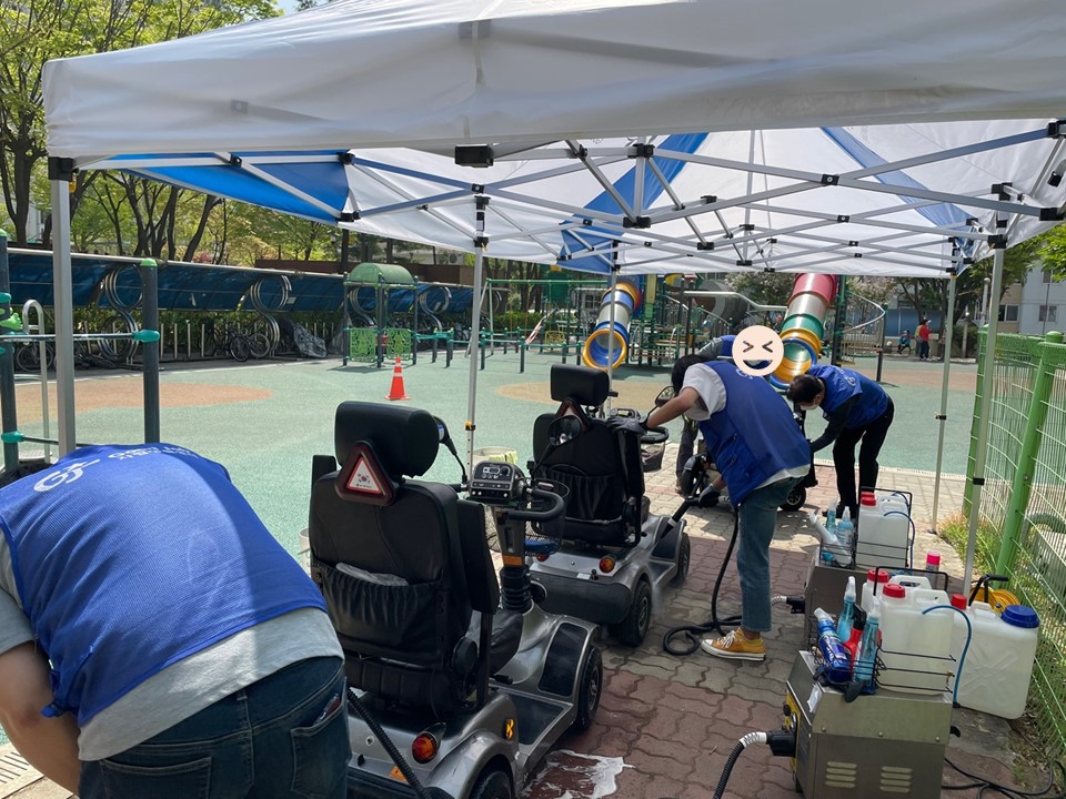 세 대의 전동 스쿠터가 나란히 줄 세워져 세척되고 있는 모습